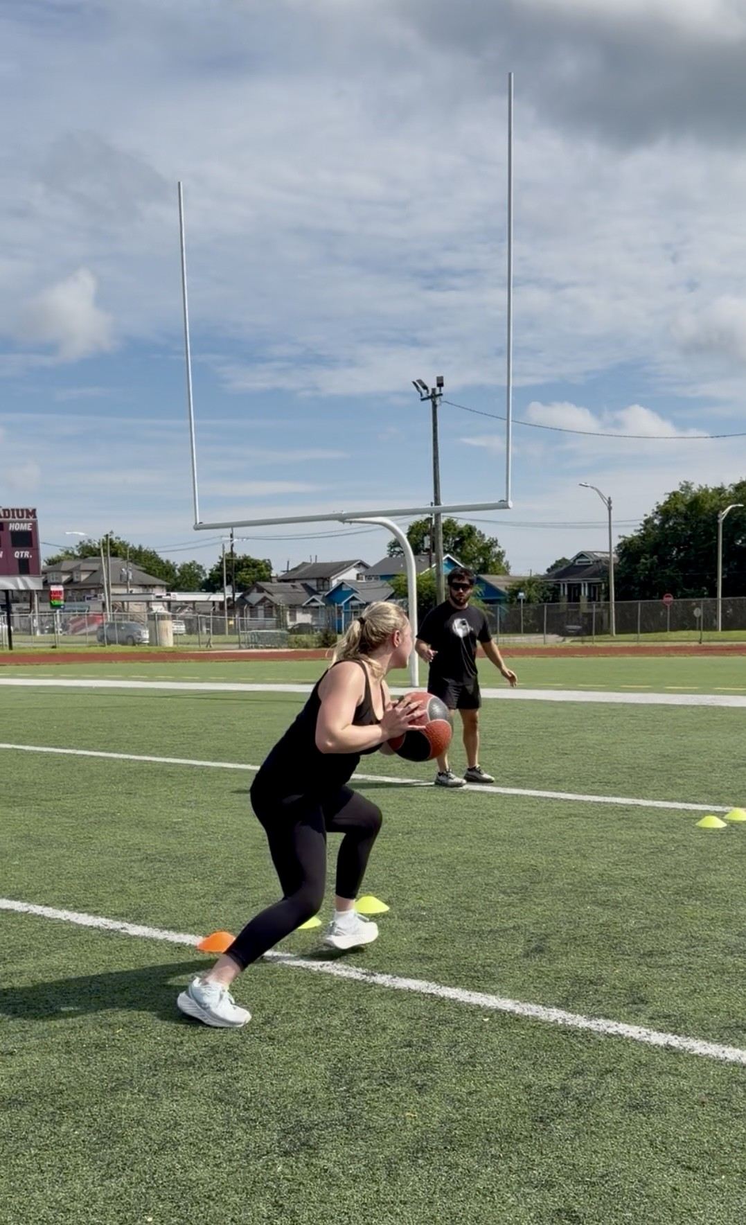 A young athlete performing a medicine ball throw drill on the field