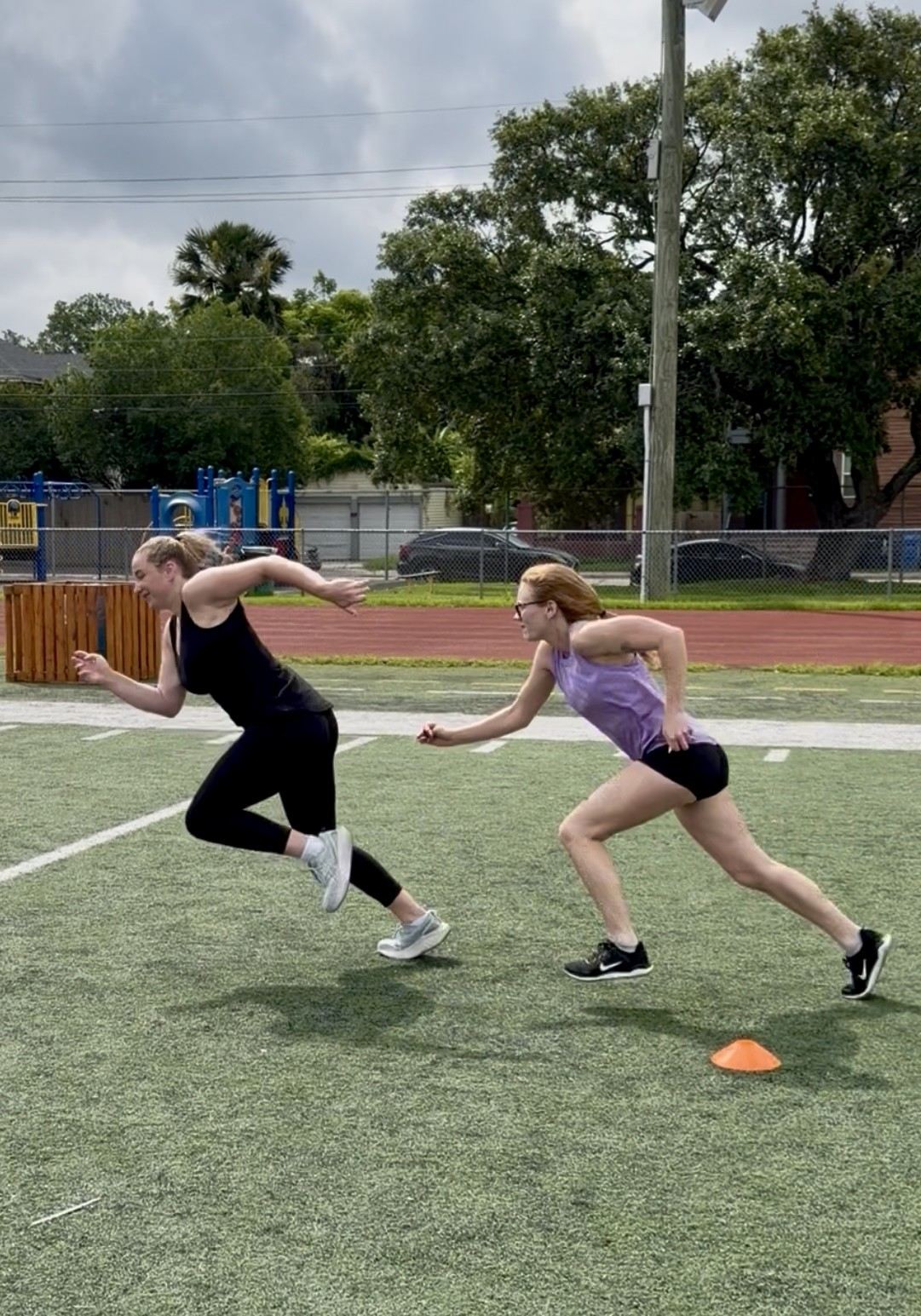 Two athletes sprinting side by side in a chase drill
